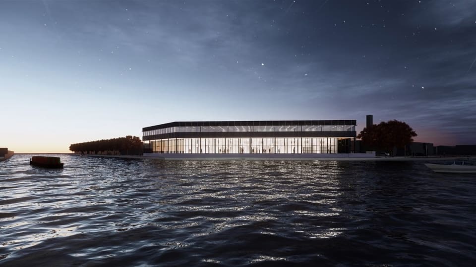 The Titaan building in The Hague at dusk, its lit glass façade reflected in the water beside it
