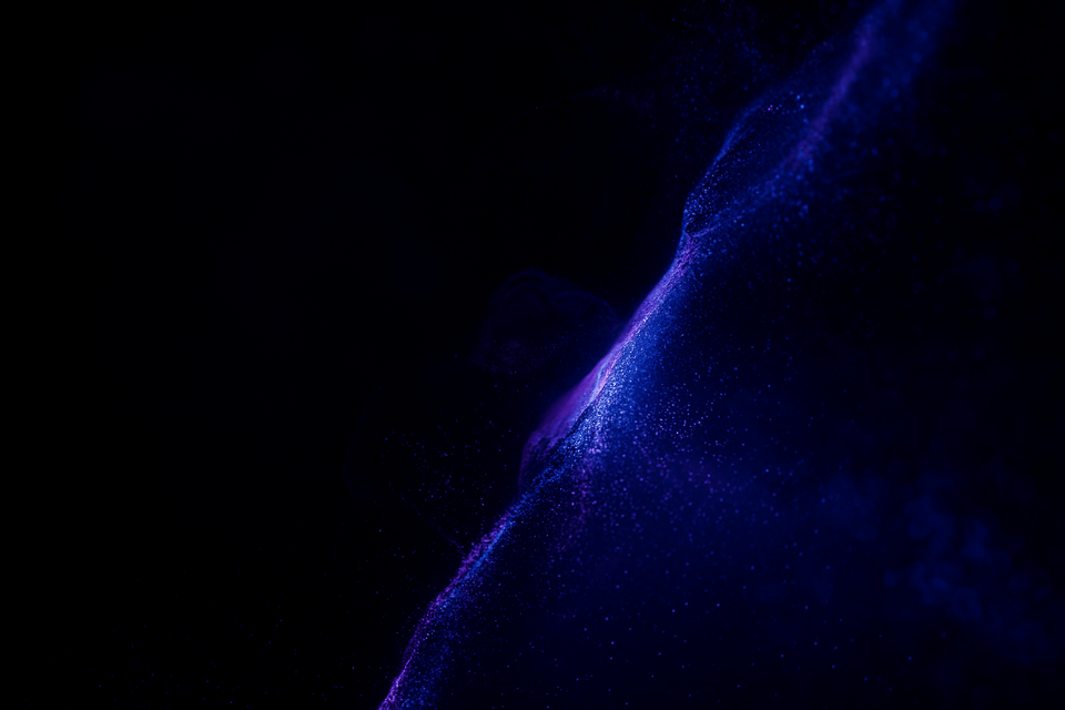 A wave of blue and purple particles sweeping through darkness, the lion just visible within it